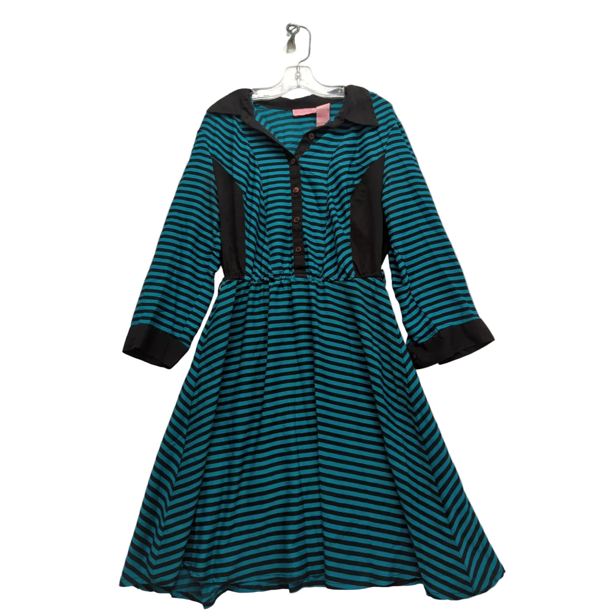 A women's long-sleeve dress with a teal and black horizontal stripe pattern, featuring solid black contrast panels on the shoulders, front placket, cuffs, and pockets, hanging on a white hanger against a wrinkled light gray fabric backdrop.